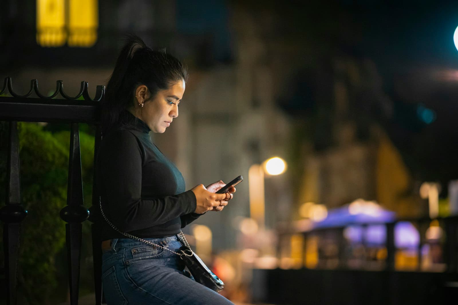 Cliente mandando mensagem pelo celular à noite